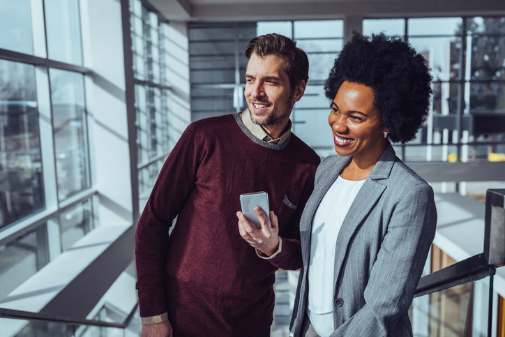 two-employees-looking-at-pricing-on-a-cell-phone