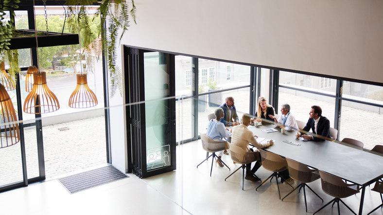 a-group-of-people-sitting-together-at-a-conference-table