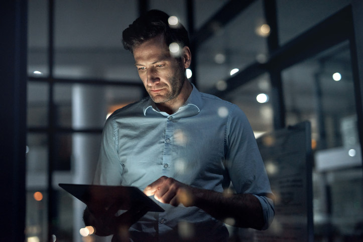 a-man-looking-at-a-screen-in-a-dimly-lit-office