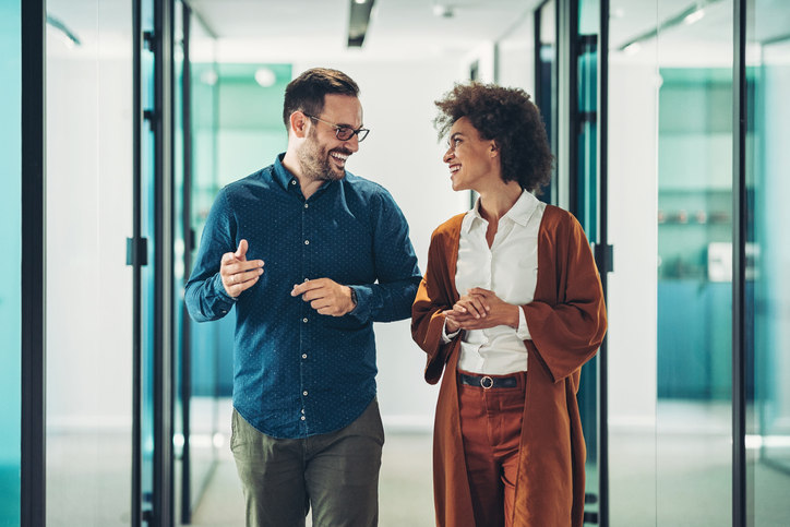 a-man-and-a-woman-walking-down-a-hallway-and-talking