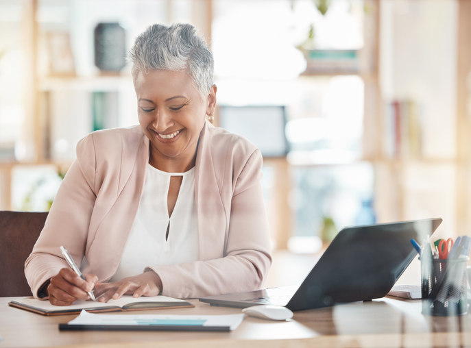 a-woman-writes-on-a-piece-of-paper-while-smiling