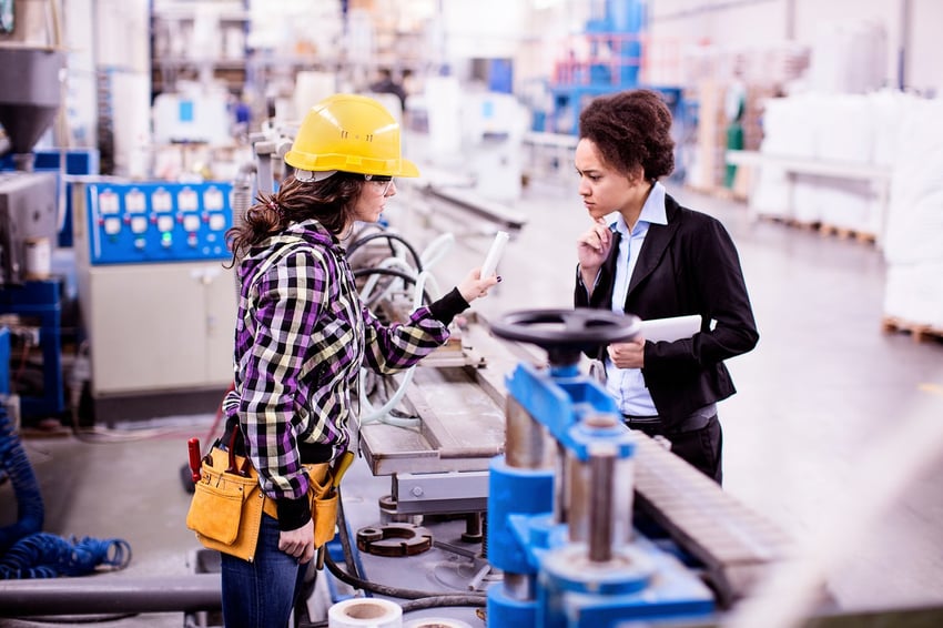 two-woman-at-an-assembly-line-looking-over-a-product