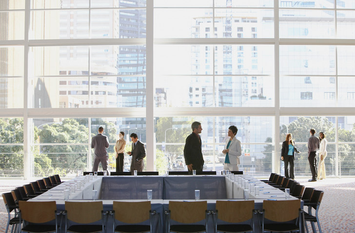 a-group-of-people-standing-around-in-a-conference-room