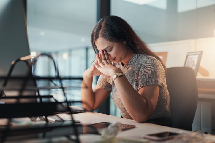 woman-sitting-at-a-desk-with-her-head-in-her-hands-out-of-stress