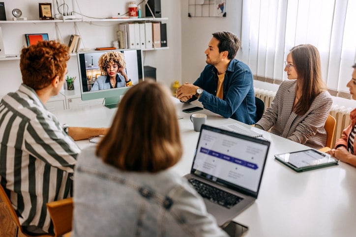  a-group-of-people-sitting-at-a-table-during-a-meeting-listening-to-someone-speaking-over-zoom