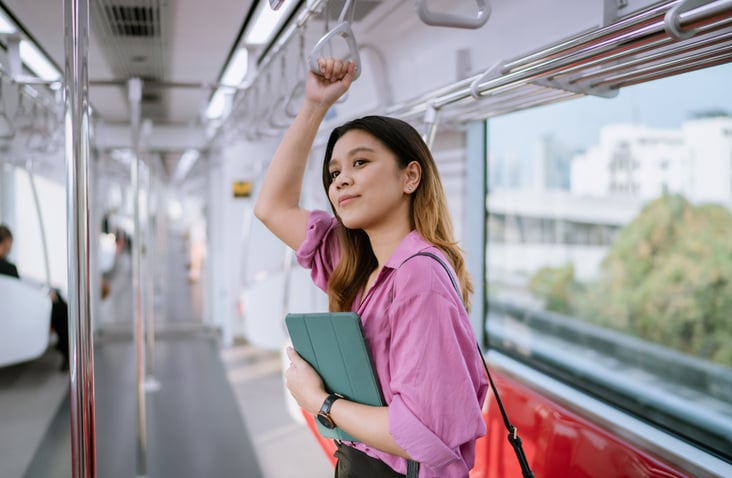 woman-standing-on-train-holding-laptop