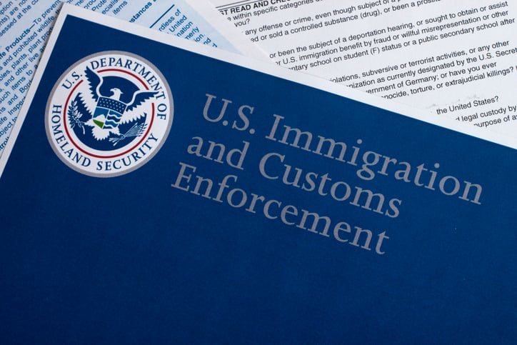 a-stack-of-papers-with-the-paper-on-the-top-reading-u-s-immigration-and-customs-enforcement